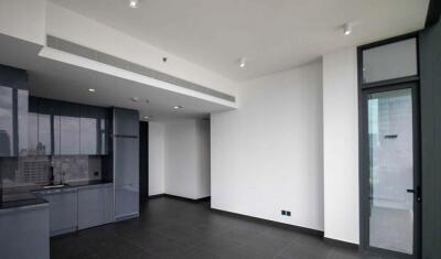 Modern open-plan living area with dark tile flooring and large windows