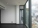 Empty room with large floor-to-ceiling windows and city view