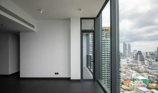 Empty room with large floor-to-ceiling windows and city view