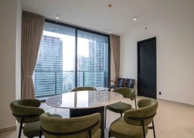 Modern dining area with round table and green chairs