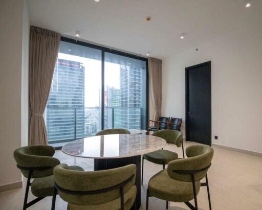 Modern dining area with round table and green chairs