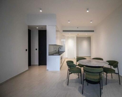 Modern dining area with round table and green chairs in a spacious living area