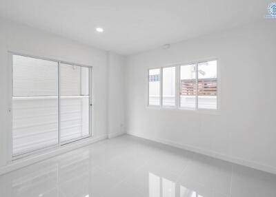 A bright and empty bedroom with large windows