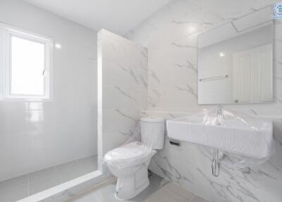 Modern bathroom with marble walls and a glass shower partition