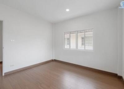 Empty bedroom with wooden floor and windows