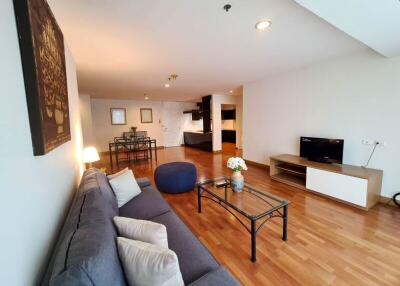 Spacious and modern living room with hardwood flooring, cozy seating area, and wall-mounted TV