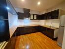 Modern kitchen with wooden flooring and black cabinetry