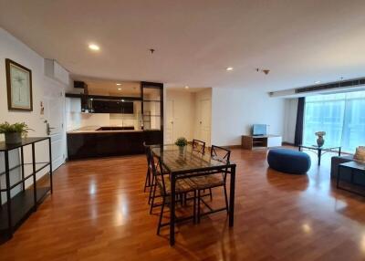 Spacious open-plan living area featuring a dining table, TV, and kitchen