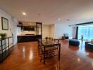 Spacious open-plan living area featuring a dining table, TV, and kitchen