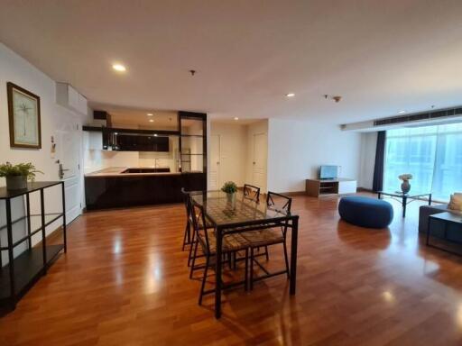 Spacious open-plan living area featuring a dining table, TV, and kitchen