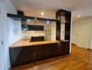 Modern kitchen with wooden flooring and black cabinets