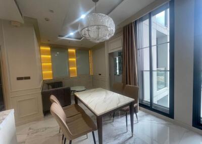 Modern dining area with large windows and chandelier