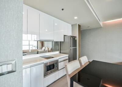 Modern kitchen and dining area with sleek white cabinets and contemporary appliances