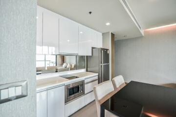 Modern kitchen and dining area with sleek white cabinets and contemporary appliances