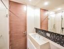 Modern bathroom with wooden door and tiled wall