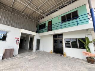 Two-story industrial building with upper level balcony and multiple entrances