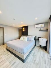 Modern bedroom with a double bed, work desk, and air conditioning