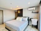 Modern bedroom with a double bed, work desk, and air conditioning