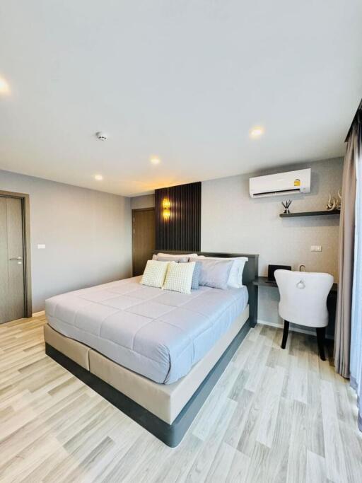 Modern bedroom with a double bed, work desk, and air conditioning