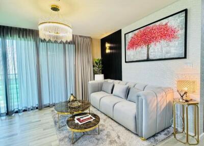 Contemporary living room with large gray sofa, chandelier, and modern decor