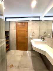 Modern bathroom with large sink and wooden door