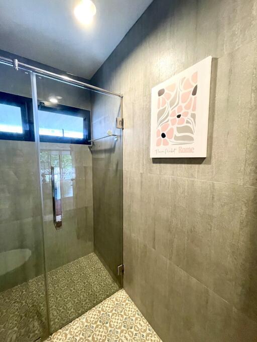 Modern bathroom with glass shower and artwork