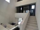 Modern atrium with stairway and large windows.