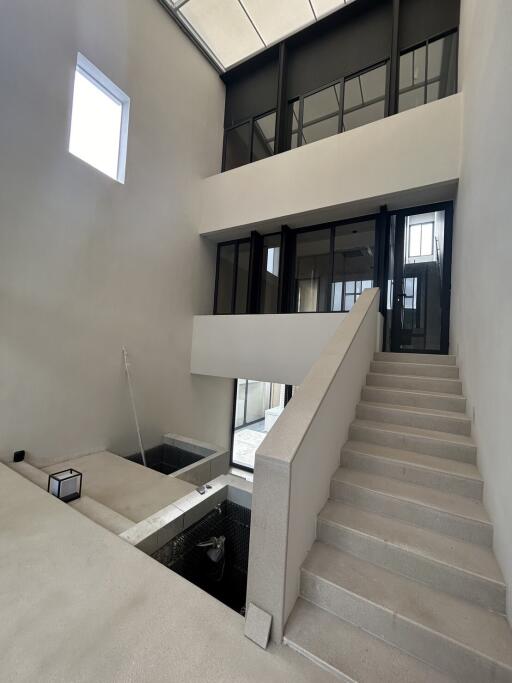 Modern atrium with stairway and large windows.