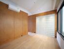 Empty room with wooden panels and glass block wall