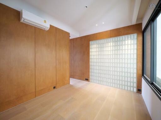 Empty room with wooden panels and glass block wall