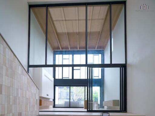 Spacious living area with high ceiling and large glass windows