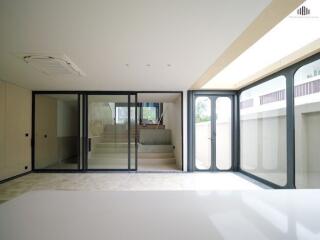 Spacious living area with large glass doors and stairway