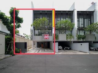 Modern townhouse exterior with trees and a for sale sign