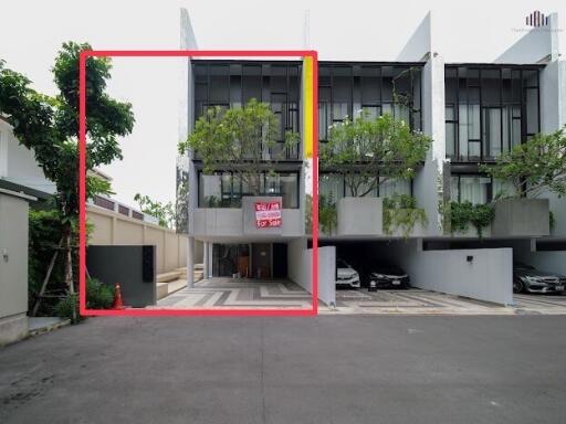 Modern townhouse exterior with trees and a for sale sign