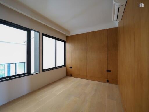 Bedroom with wooden walls and large windows