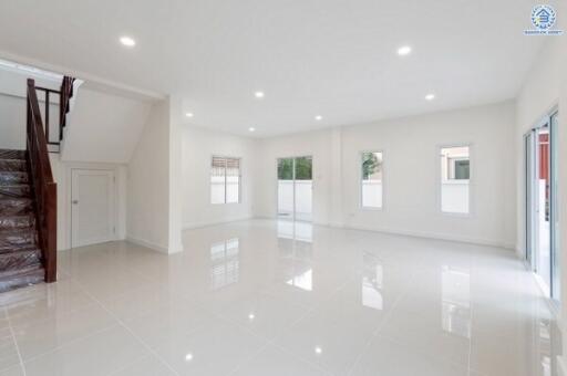 Spacious main living area with large windows and staircase