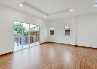 Spacious living room with hardwood floors and large windows