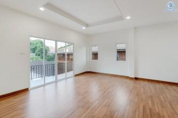 Spacious living room with hardwood floors and large windows