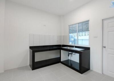 Modern kitchen with black countertops and tiled backsplash