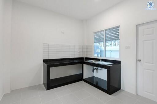 Modern kitchen with black countertops and tiled backsplash