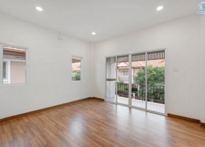 Spacious living room with wooden flooring and large windows