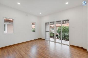 Spacious living room with wooden flooring and large windows