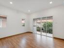 Spacious living room with wooden flooring and large windows