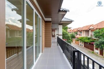 Spacious balcony with sliding glass doors and view of the neighborhood