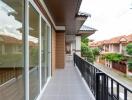 Spacious balcony with sliding glass doors and view of the neighborhood