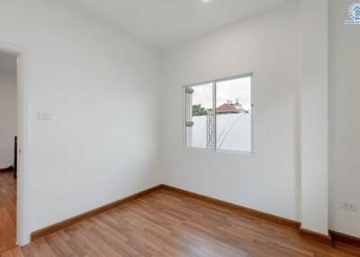 Small bedroom with window and wooden floor