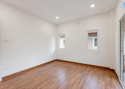 spacious empty room with hardwood flooring and windows