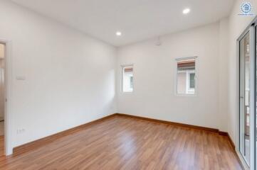 spacious empty room with hardwood flooring and windows