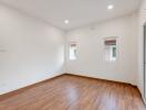 spacious empty room with hardwood flooring and windows