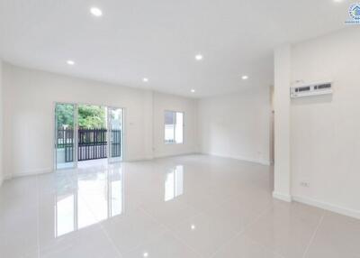 Spacious and well-lit living area with large windows and tiled flooring